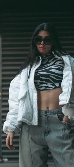 A street-style photo of an outfit: a white puffer jacket, a zebra-print top and light wash jeans.